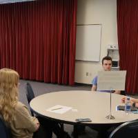 A volunteer and two students sitting together at the 30 Minute Mentors Event